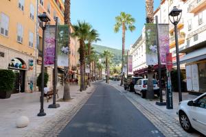 a street in a city with palm trees and buildings at Apt terrasse centre historique in Grasse