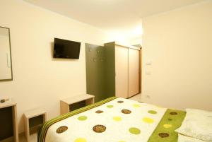 1 dormitorio con 1 cama y TV en la pared en Kraljič - Primož Čotar en Dornberk