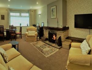 a living room with a fireplace and a tv at Woodpeckers Cottage in Scarborough
