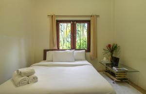 um quarto com uma grande cama branca e uma janela em Krabi Green Hill Pool Villas em Ban Nong Thale