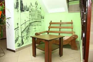 een stoel en tafel in een kamer met een tekening aan de muur bij Hotel Miks in Chernihiv