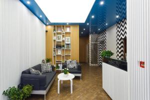 a lobby with couches and a table and a book shelf at CityResidence Aparthotel in Sofia