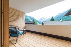 balkon z krzesłem i widokiem na góry w obiekcie Hotel Alpenrast w mieście Riva di Tures