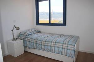 een kleine slaapkamer met een bed en een raam bij ATICO-DUPLEX CERCA DE DENIA Y LA PLAYA -(KM 0,5 LES MARINES) in Denia