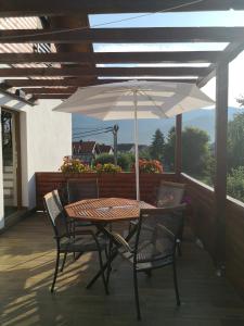 a table and chairs with an umbrella on a patio at Accommodation Plitvice in Korenica