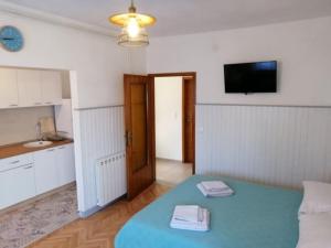 a room with a blue bed and a kitchen at Studio apartment Vigo - Rijeka in Rijeka