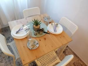 a wooden table with white plates and utensils on it at Studio apartment Vigo - Rijeka in Rijeka