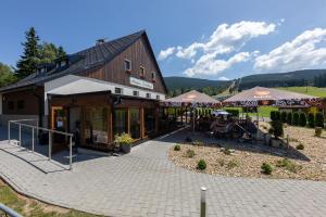 a building with a patio in front of it at Penzion Neubauer in Ostružná