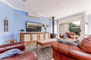 a living room with two couches and a table at WALKIN ON SUNSHINE - STROLL TO BEACH BREAK in Inverloch