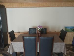 a dining room table with chairs and a vase of flowers at Lali`s Guest House in Juta in Jut'a