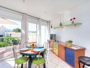 uma cozinha com mesa e cadeiras e uma cozinha com varanda em Apartment Palmiers I-6 by Interhome em Llançà