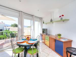 a kitchen with a table and chairs and a kitchen with a balcony at Apartment Palmiers I-6 by Interhome in Llança