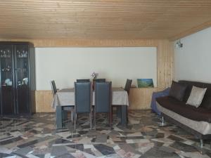 a dining room with a table and a couch at Lali`s Guest House in Juta in Jut'a