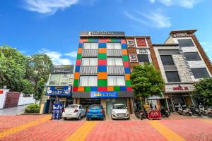 un edificio colorido con coches estacionados frente a él en Hotel Destination, en Chandīgarh