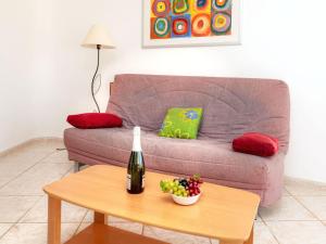 uma sala de estar com um sofá e uma mesa com uma garrafa de vinho em Apartment Palmiers I-6 by Interhome em Llançà