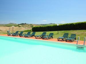 a row of chairs sitting next to a swimming pool at Holiday Home Capanna by Interhome in Casetta