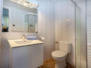 Baño blanco con aseo y lavamanos en Apartment Rosa Maria by Interhome, en Llançà