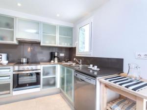 a kitchen with white cabinets and a sink at Apartment Matthias-2 by Interhome in Llança