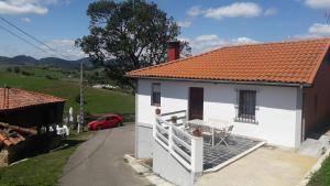 Casa blanca con balcón y techo rojo en Alvares de Corvera, en El Pontón
