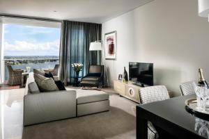 a living room with a couch and a tv at Fraser Suites Perth in Perth