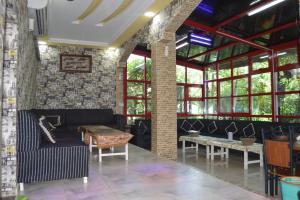 a room with a couch and tables and windows at Happiness Farm in Hatta