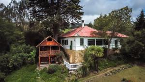 una casa con techo rojo en una colina en Posada Ingapirca, en Ingapirca