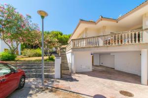 a red car parked in front of a house at C250 Villa Canta by Mallorca Villa Selection in Playa de Muro