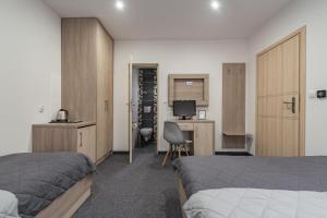 a hotel room with two beds and a desk and a computer at Willa Lala in Szczawnica