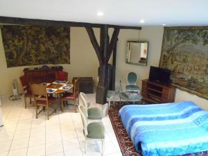 Schlafzimmer mit einem Bett, einem Tisch und Stühlen in der Unterkunft LE GITE DU COLOMBIER in Bracquetuit