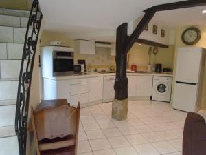 a kitchen with white appliances and a staircase in it at LE GITE DU COLOMBIER in Bracquetuit