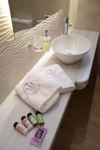 a bathroom counter with a sink and a towel at LEVANTA HOTEL SPETSES in Spetses