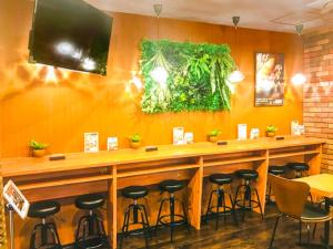 a bar in a restaurant with stools at HOTEL LiVEMAX Umeda WEST in Osaka +19 photos