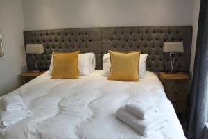een slaapkamer met een groot wit bed met gele kussens bij Apt 1, Frasers Close, Kirkwall in Kirkwall