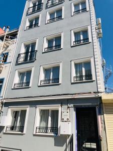 Edificio alto de color blanco con ventanas y balcones en The Empress Theodora Hotel ll en Estambul