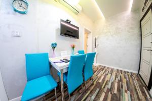 a room with blue chairs and a table and a tv at Sofia Colour Life Apartment -No Window Apartment in Sofia