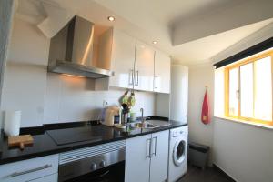 Casa2_Praia_Beach_House في بورتيماو: مطبخ مع حوض وغسالة ملابس