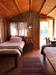 a bedroom with two beds in a wooden cabin at Kololo Guesthouse in Katima Mulilo