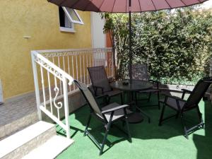 a patio with a table and chairs and an umbrella at Otroiza Hotel in Cilaos