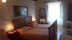 1 dormitorio con 2 camas, espejo y ventana en Apartments Lovor en Silba
