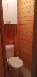 a bathroom with a white toilet and wooden walls at ISATIS 19 in Ignaux