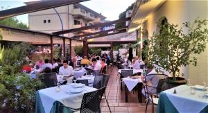 a group of people sitting at tables at a restaurant at Hotel Pop in Cala Gonone