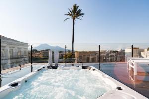 a hot tub on top of a building with a palm tree at Dream House Pompei in Pompei