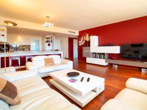 una sala de estar con muebles blancos y una pared roja. en Apartment Altea La Nova-10 by Interhome, en Bernia