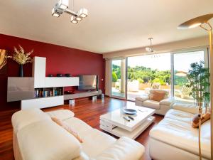 una sala de estar con muebles blancos y paredes rojas. en Apartment Altea La Nova-10 by Interhome, en Bernia