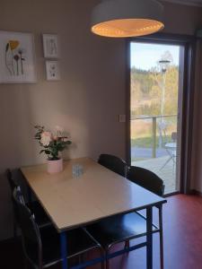 een eettafel met stoelen en een vaas met bloemen bij Måvikens Camping in Måviken