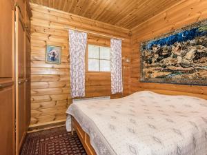 een slaapkamer met een bed in een blokhut bij Holiday Home Eden by Interhome in Kuusa