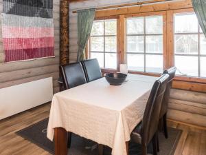 a dining room with a table and chairs and windows at Holiday Home Vuokatticottage f by Interhome in Vuokatti