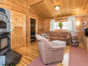 een woonkamer met een bank en een tv bij Holiday Home Eden by Interhome in Kuusa