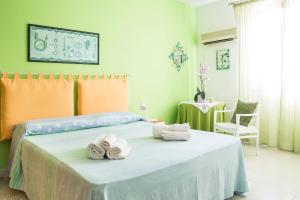 - une chambre avec un lit et des serviettes dans l'établissement B&b Margherita, à Calasetta