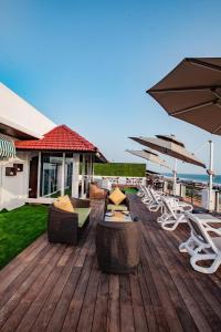 a deck with chairs and tables and umbrellas at Royale Exotica, Goa in Calangute